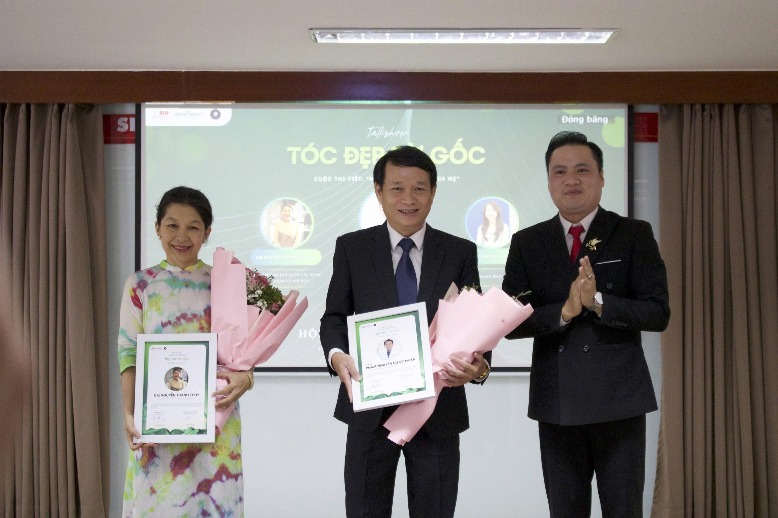 ThS. Trần Trắng – Phó Phòng Tuyển sinh & Công tác sinh viên - Trường Đại học Quốc tế Sài Gòn tặng hoa các diễn giả tại hội thảo.